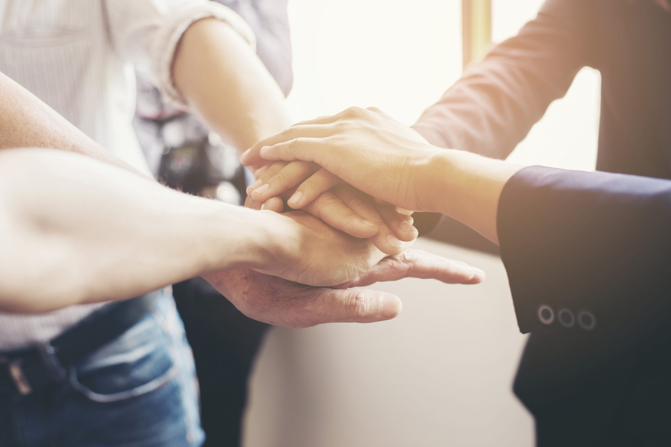 Concept of teamwork: Close-Up of hands business team showing unity with putting their hands together.